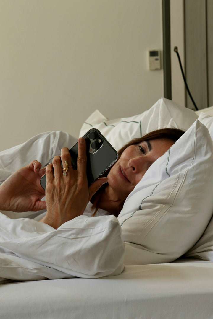 Woman with smartphone in bed